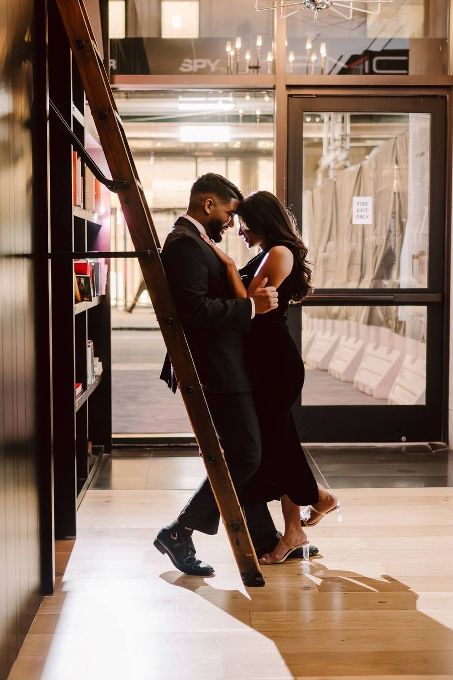 Dip kiss beside a rolling library ladder