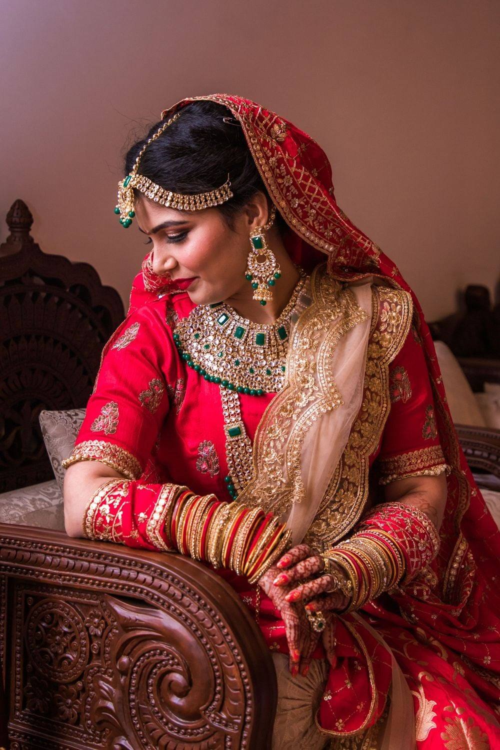 Bride in red lehenga with traditional jewelry