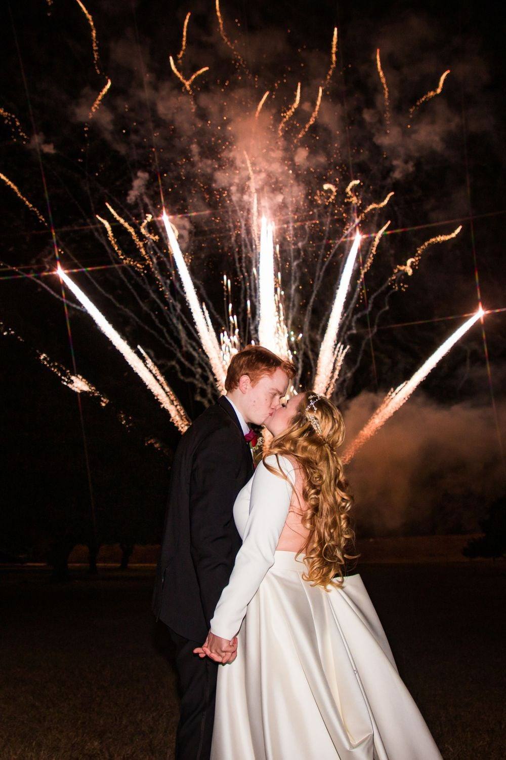 First-dance kiss beneath fireworks