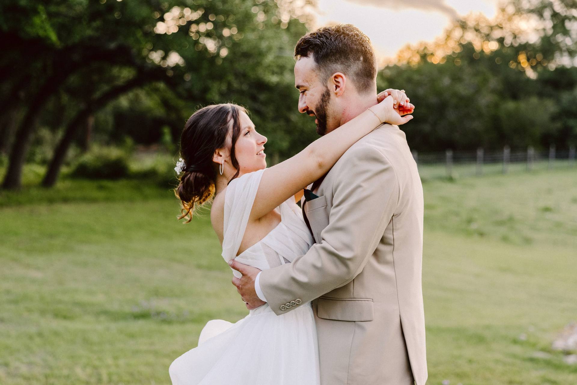 Bride and groom embracing in a golden-hour meadow