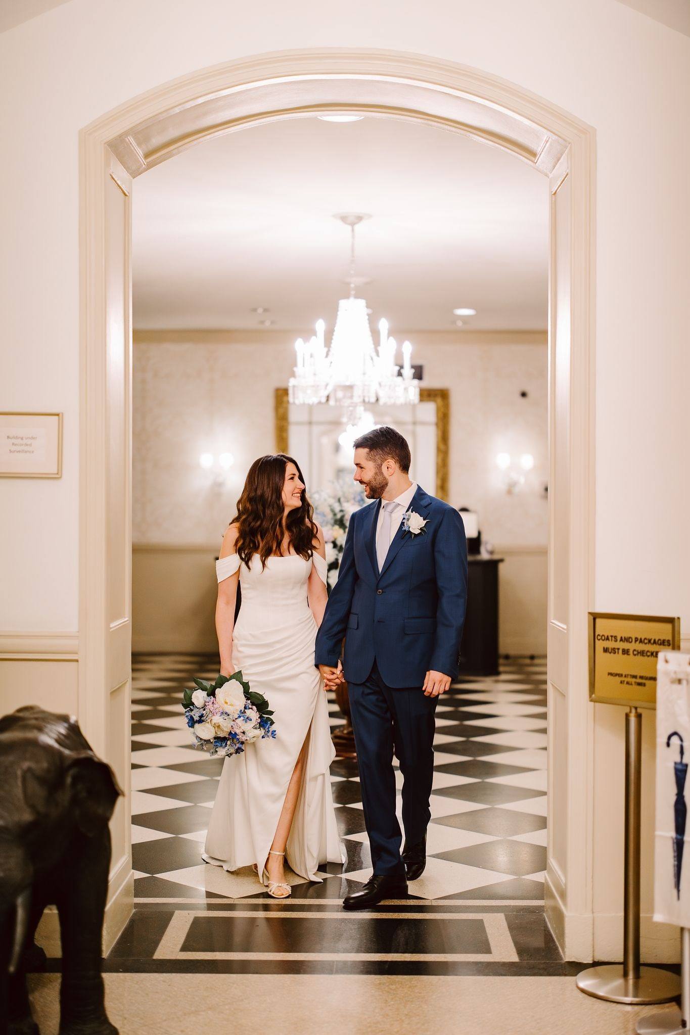 Couple in a marble checkered hallway with their dog