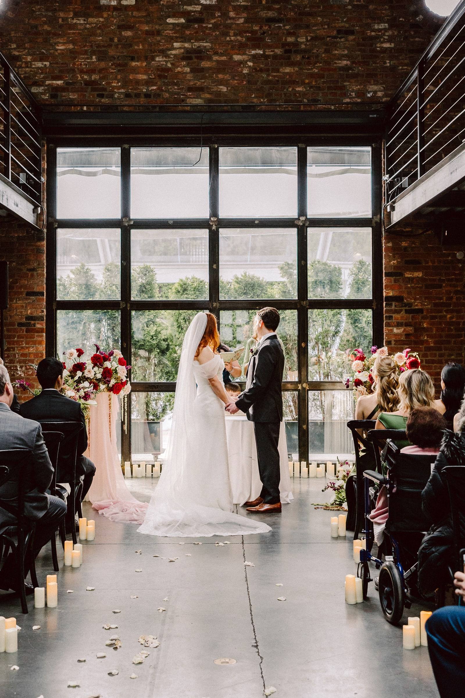 Ceremony beneath towering steel-framed windows