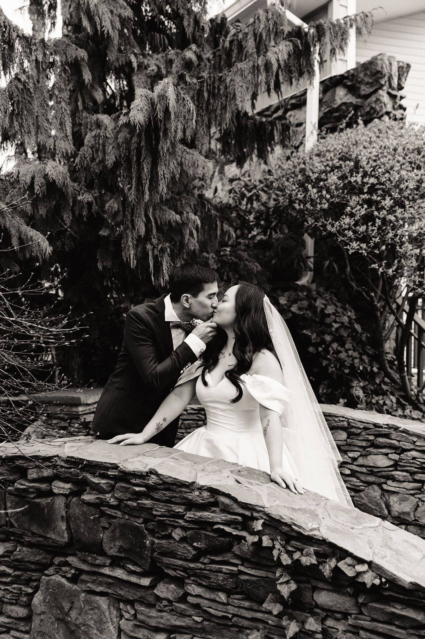 Dip kiss on a stone footbridge, black and white
