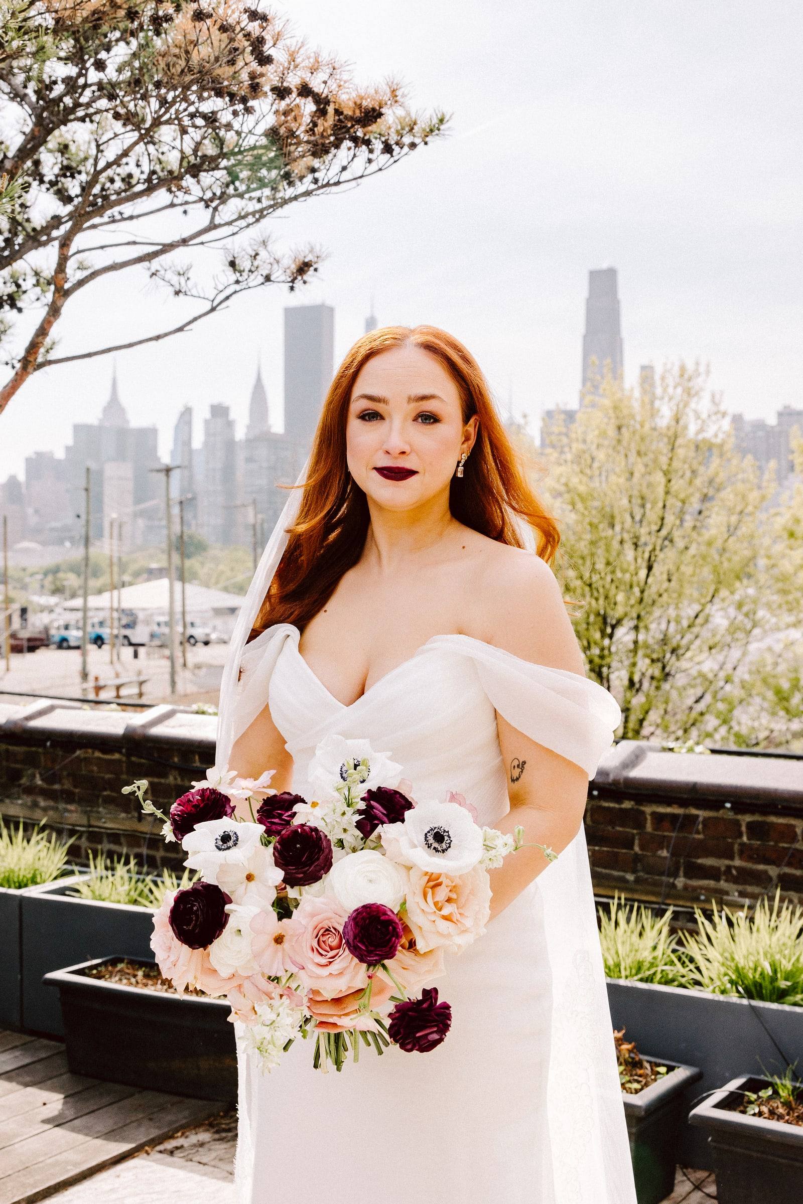 Bridal portrait with dark-accent bouquet and city skyline
