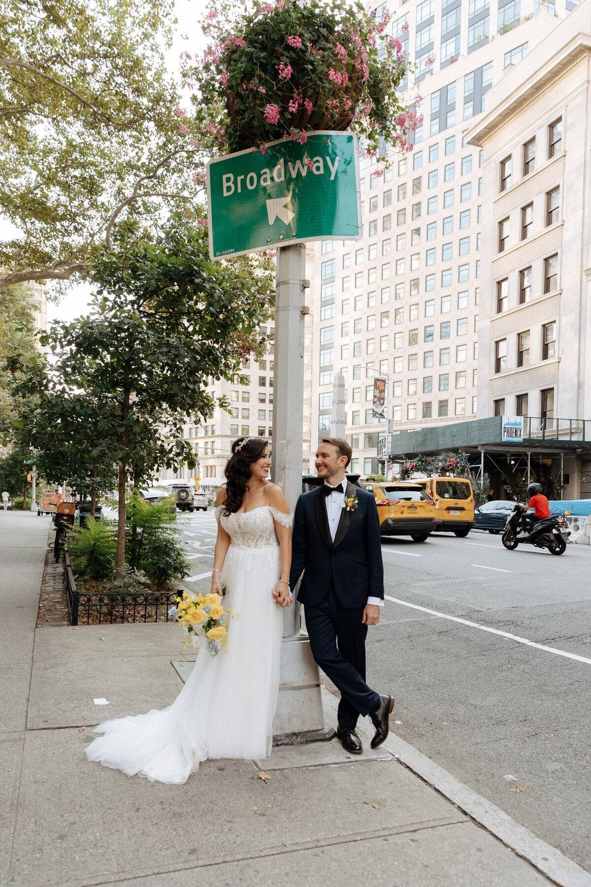 Bride and groom under the Broadway street sign