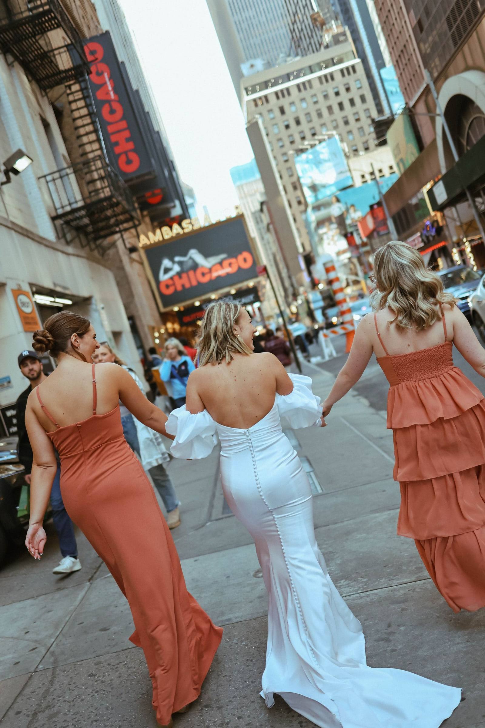 Bridesmaids crossing the city street