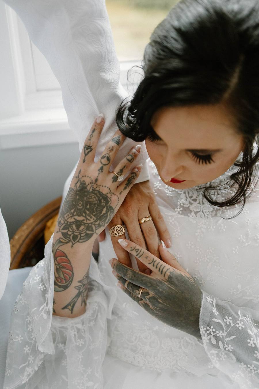Tattooed bride adjusting her earring