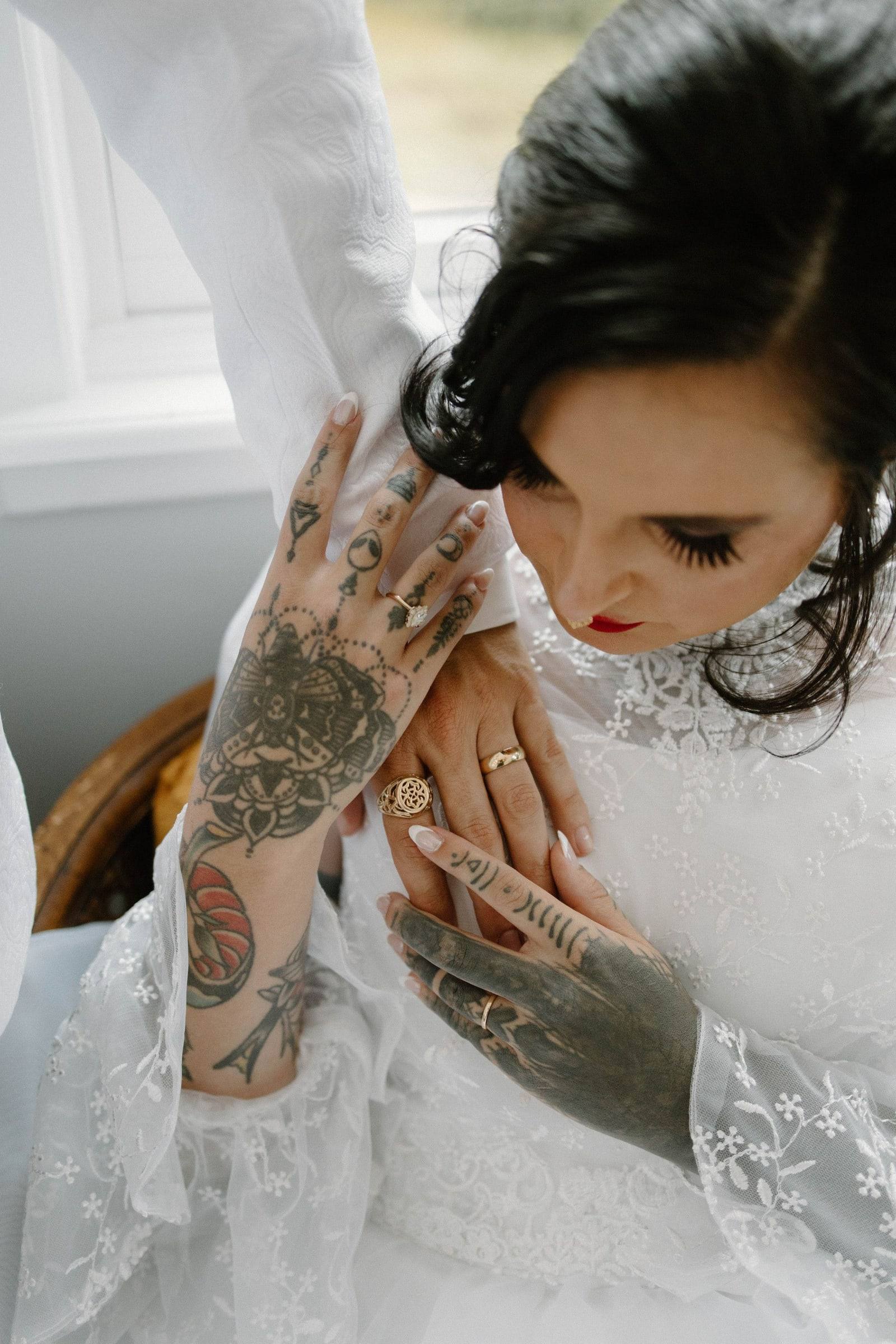 Tattooed bride adjusting her earring