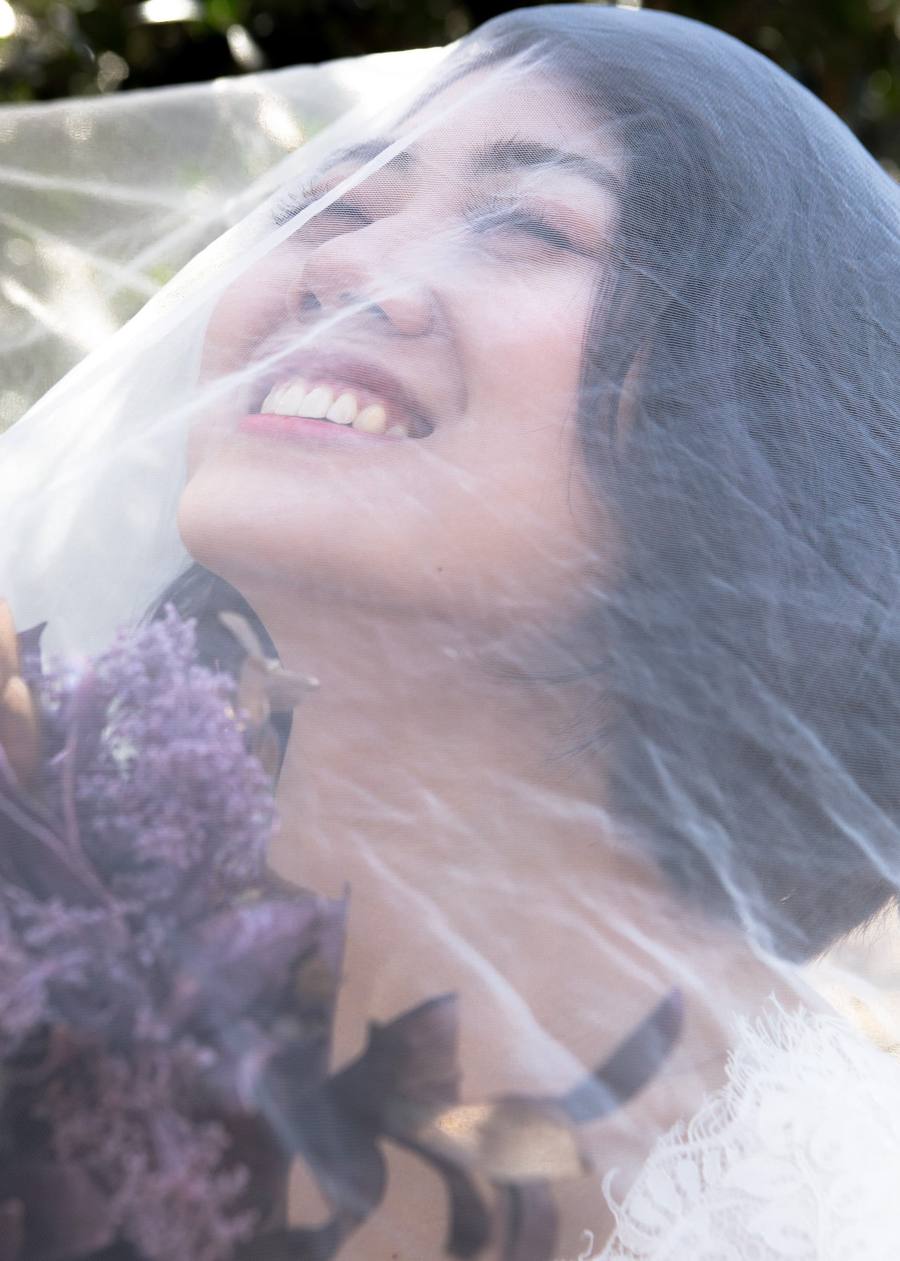 Laughing bride beneath the veil