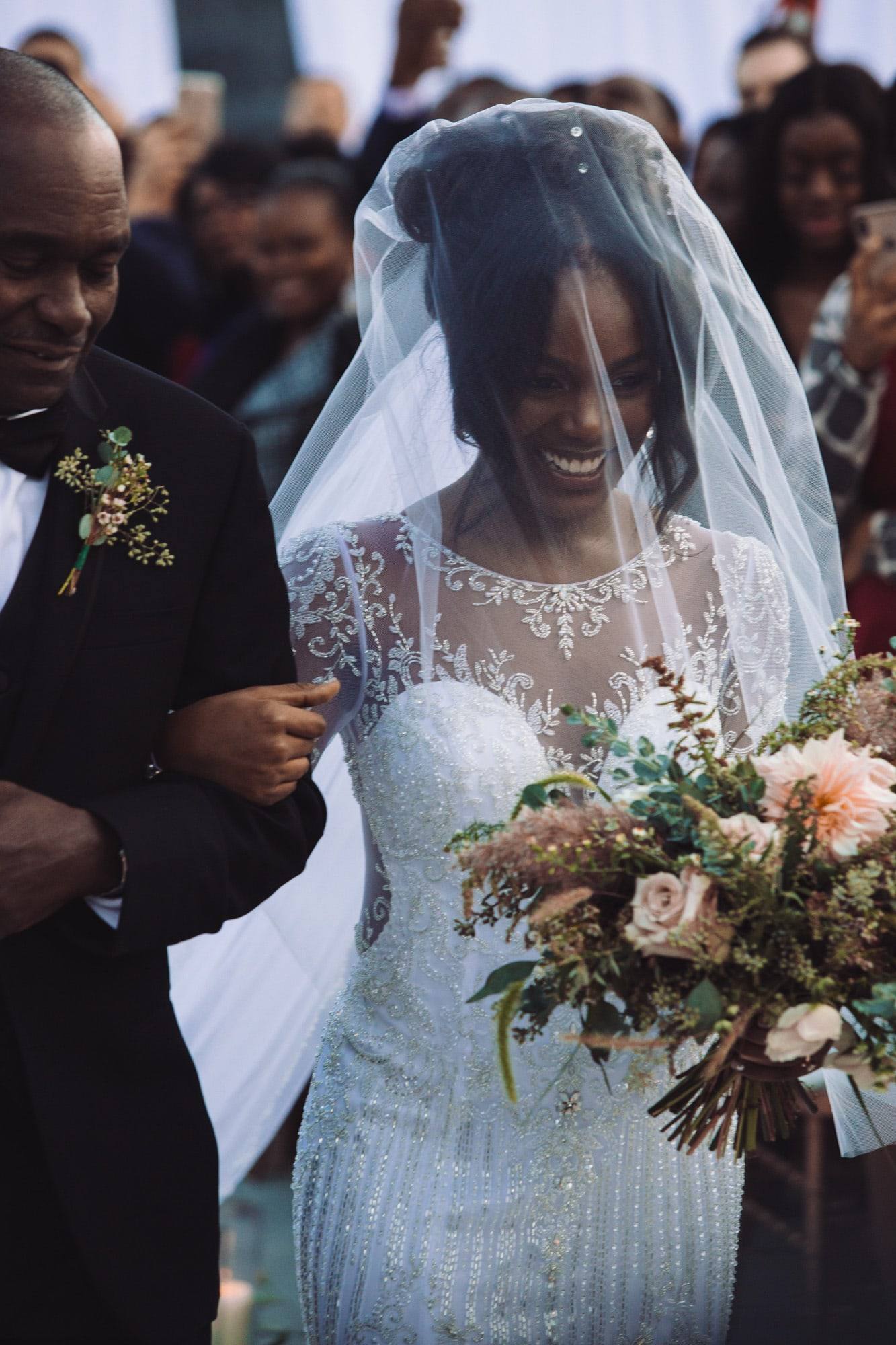 Bride walking the aisle with bouquet and veil