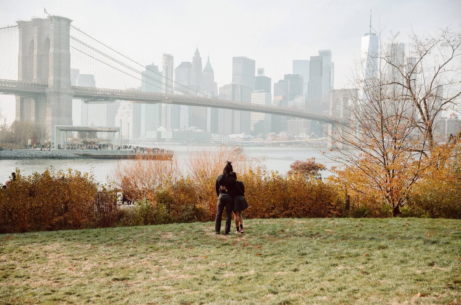 Couple in the field below the Brooklyn Bridge
