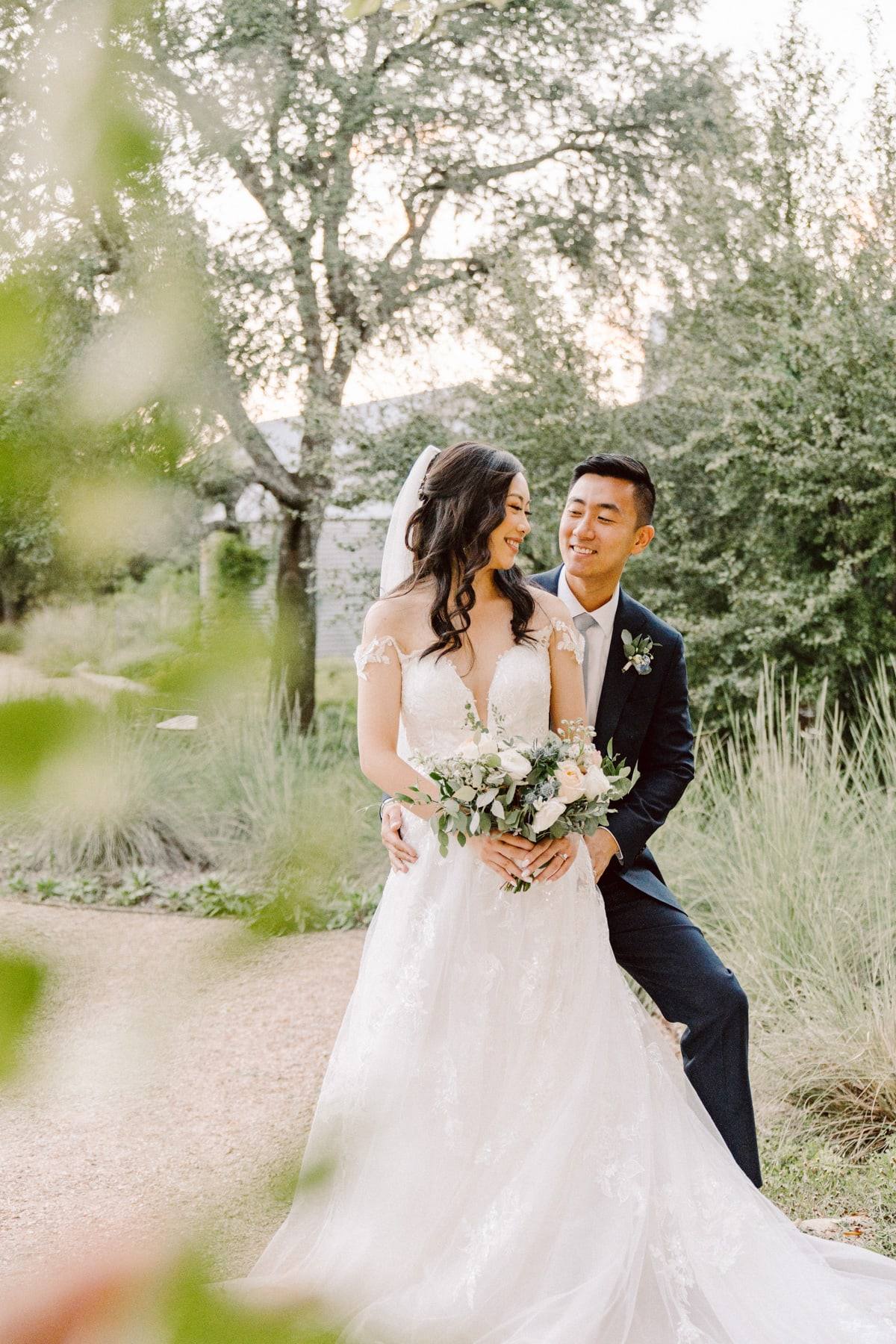 Bride and groom with bouquet in the field