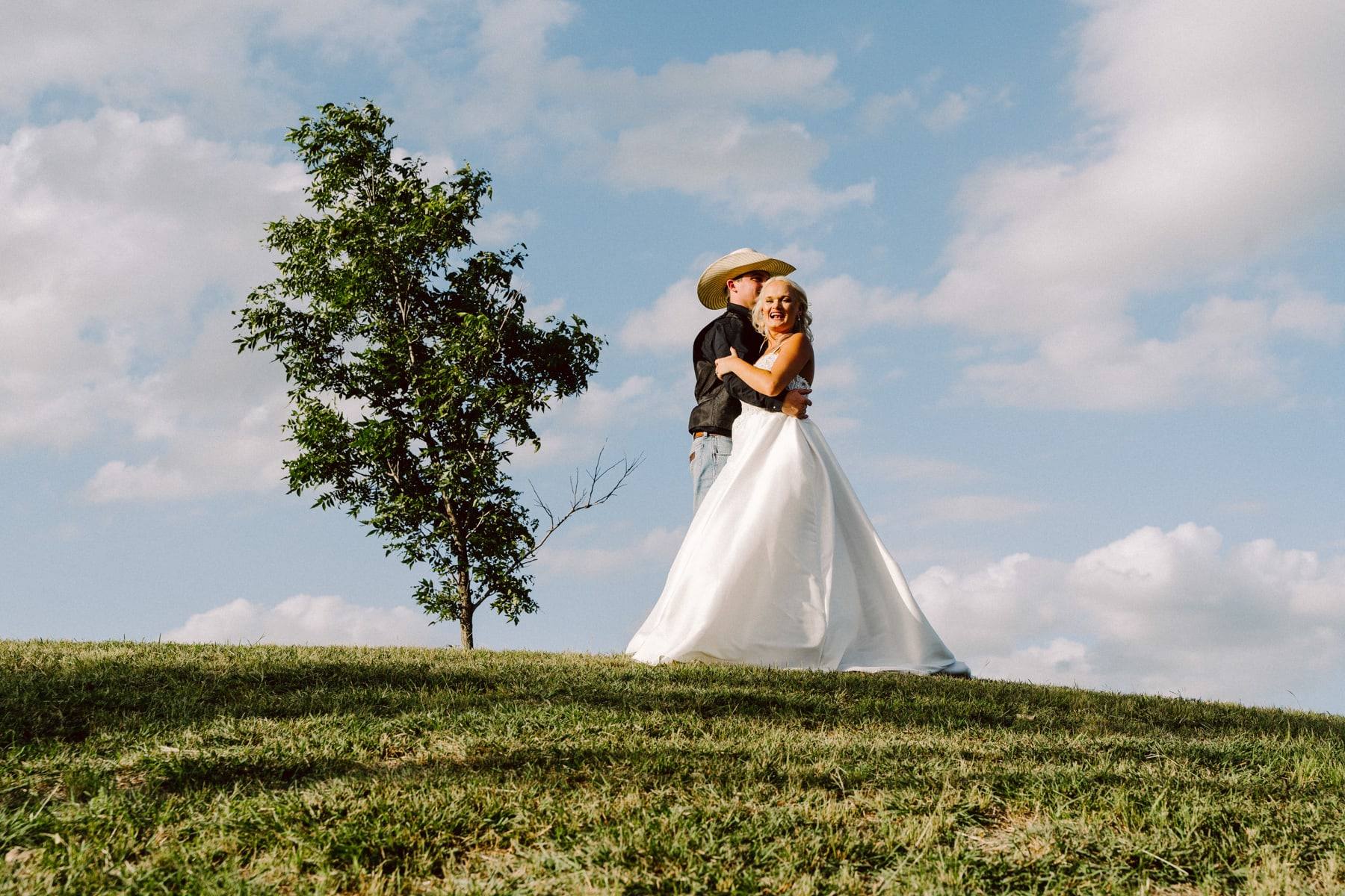 Bride on a hilltop under a dramatic sky