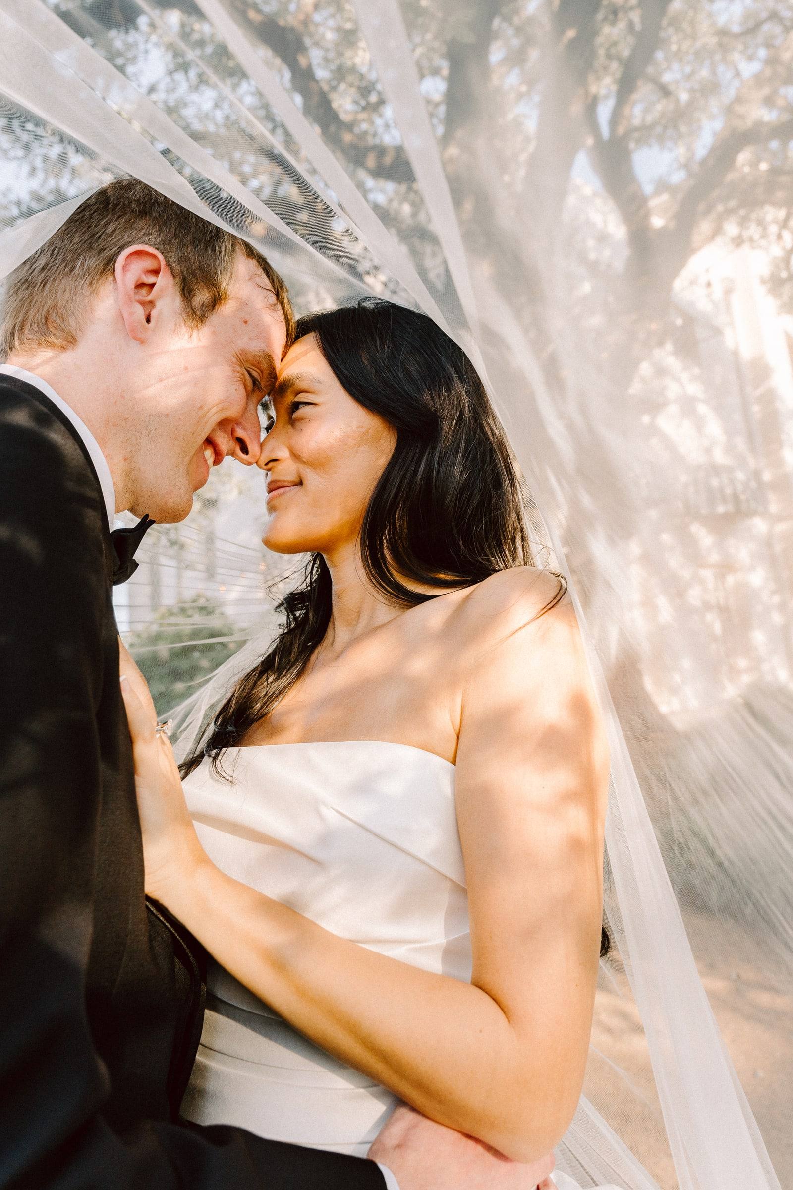 Foreheads together under a translucent veil