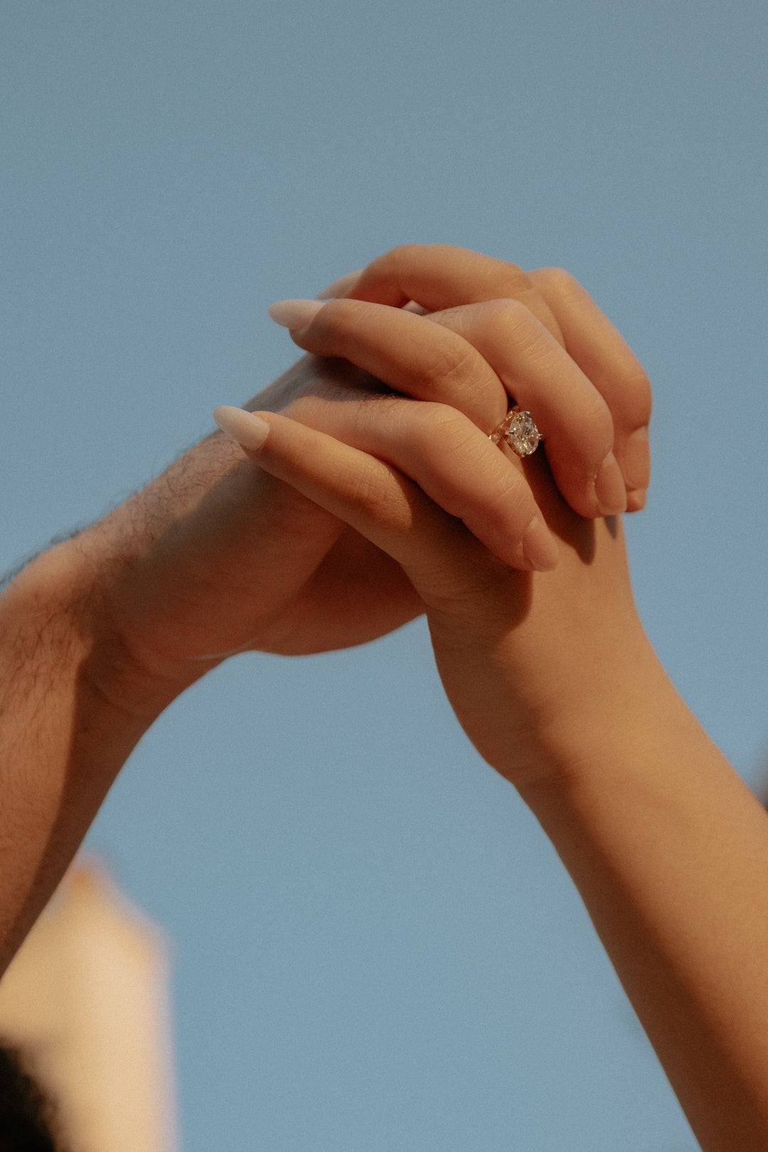 Interlocked hands against the sky