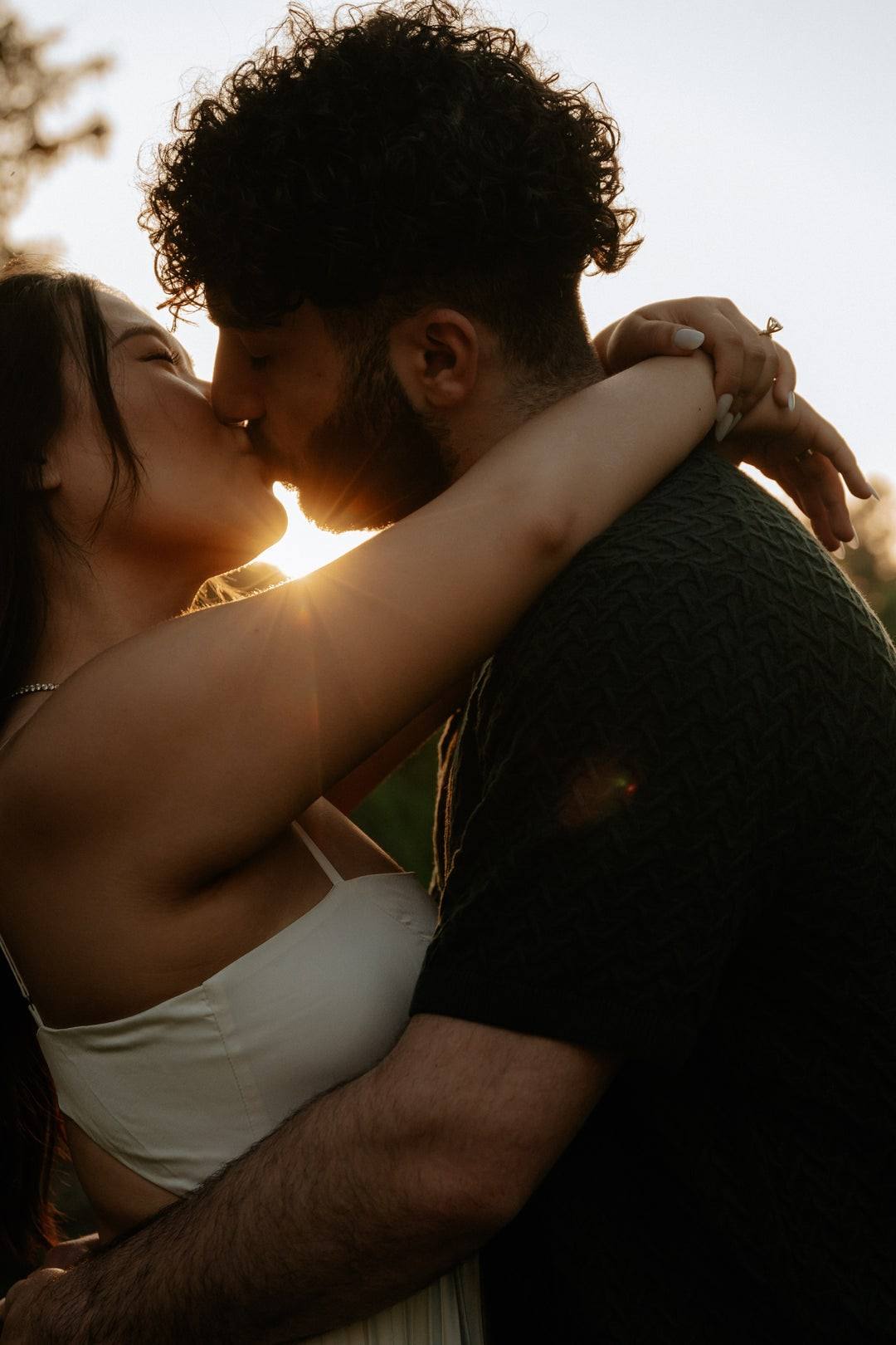 Golden-hour kiss with sun flare