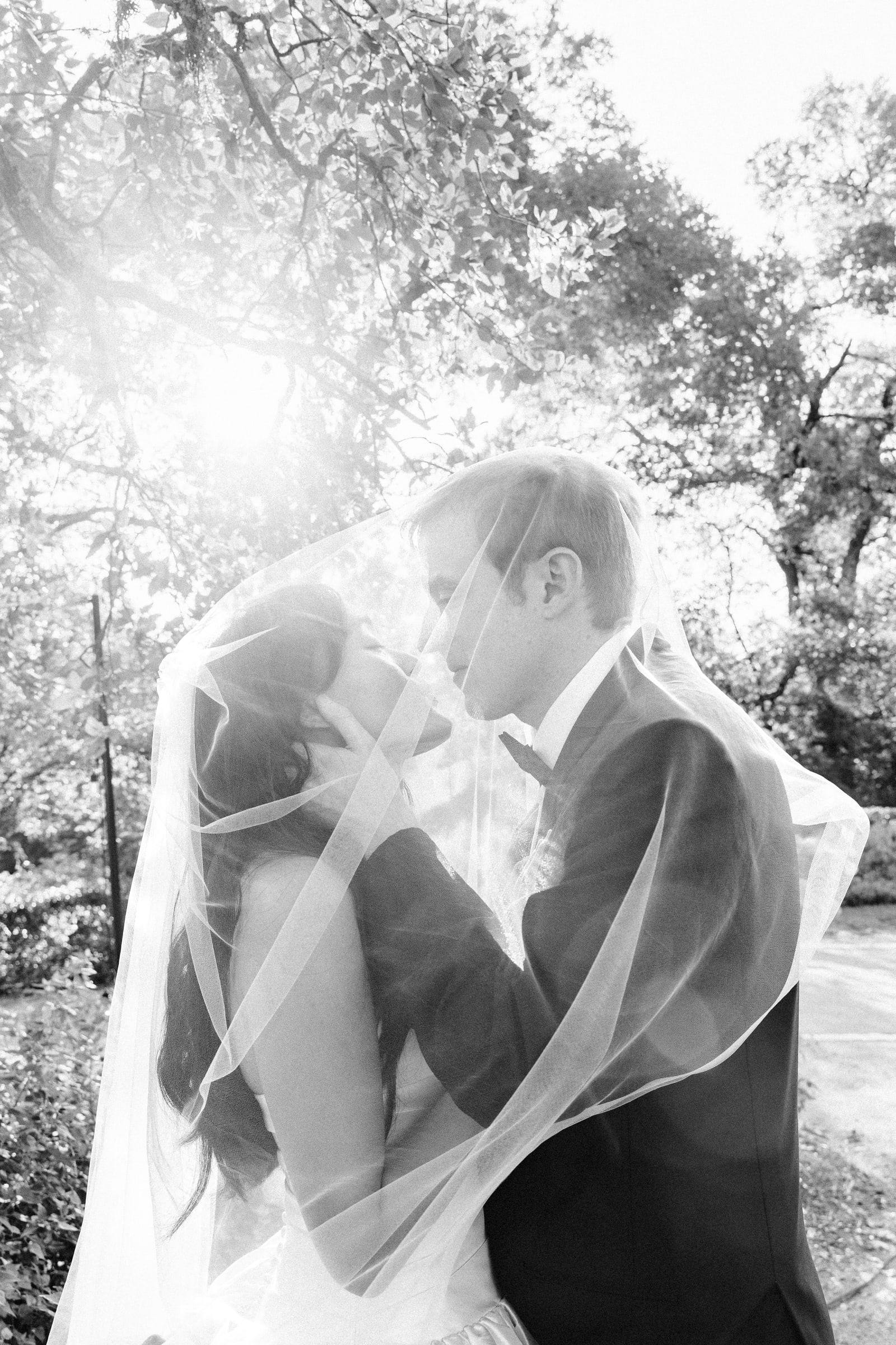 Veiled kiss in filtered sunlight, black and white
